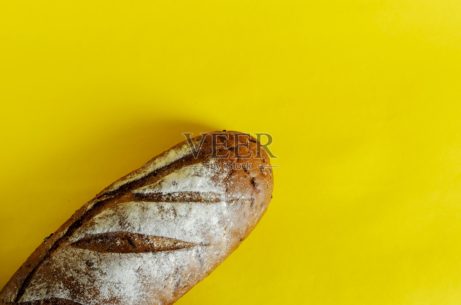 面包在黄色背景上的新鲜烤的黑麦面包照片摄影图片