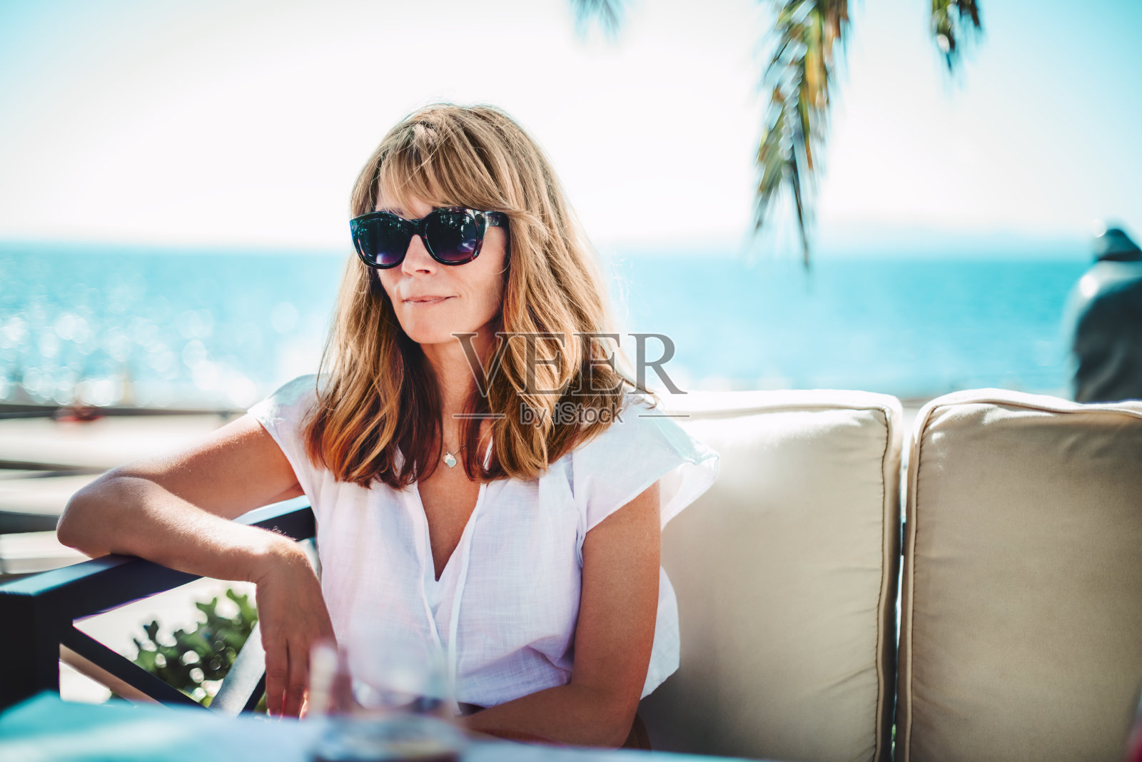 快乐的女人享受阳光，同时放松户外沙发照片摄影图片