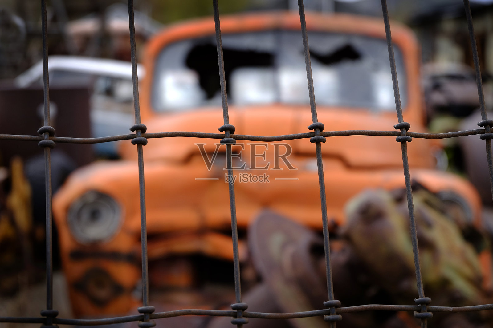 为了安全，在铁丝网后面丢弃破旧的汽车照片摄影图片