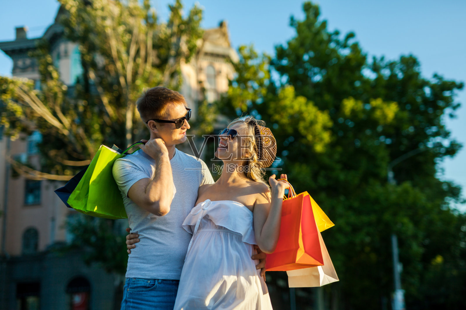 幸福的人们与丈夫和怀孕的妻子在城市街道购物的肖像照片摄影图片