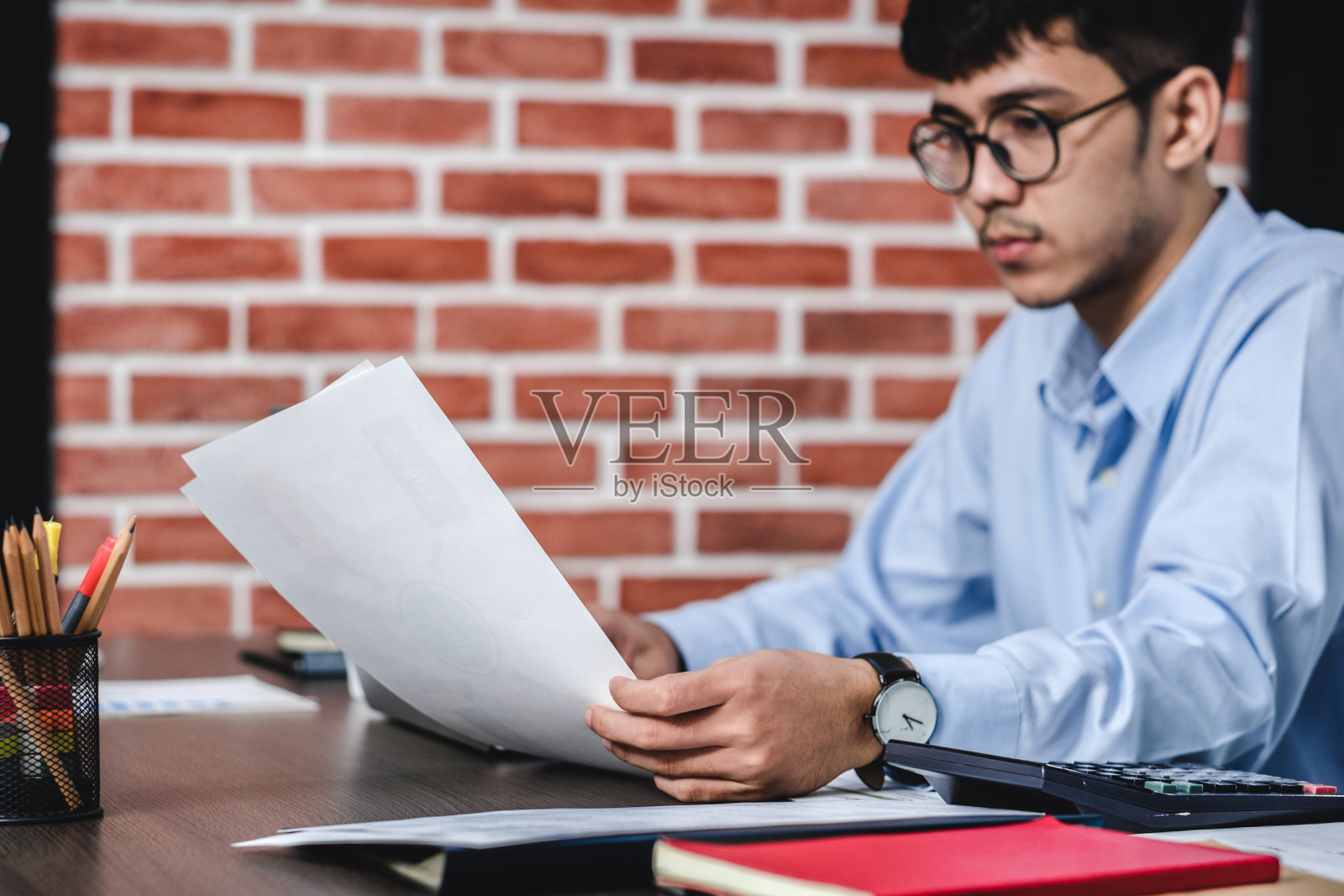 亚洲商人在办公室用笔记本电脑和文件工作。数字工作流在线商务生活理念。照片摄影图片