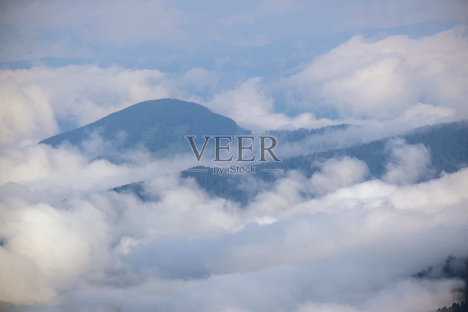 云雾笼罩着山顶的轮廓。照片摄影图片