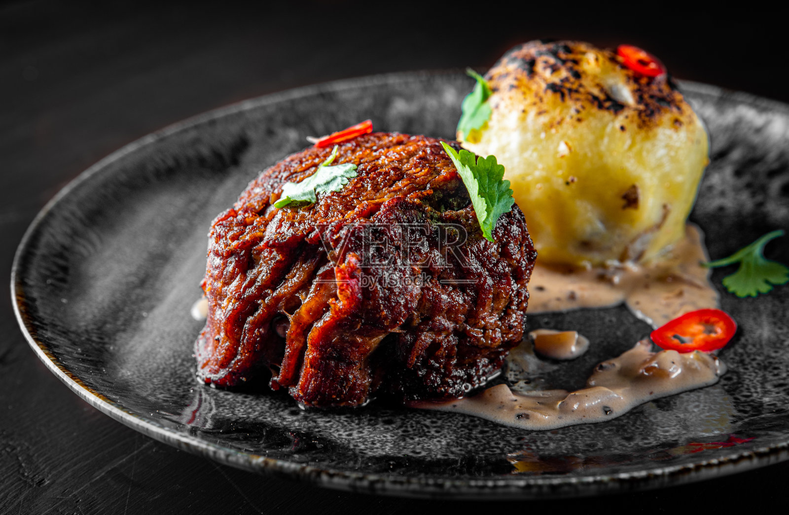 木桌上的烤牛排、菲力牛排、土豆和酱汁照片摄影图片