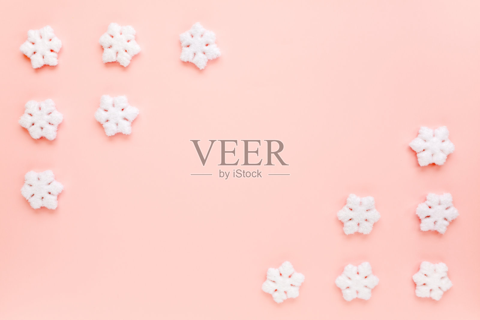 圣诞节框架与白色的圣诞雪花在粉红色的背景。圣诞节组成、墙纸。平躺，俯视图照片摄影图片