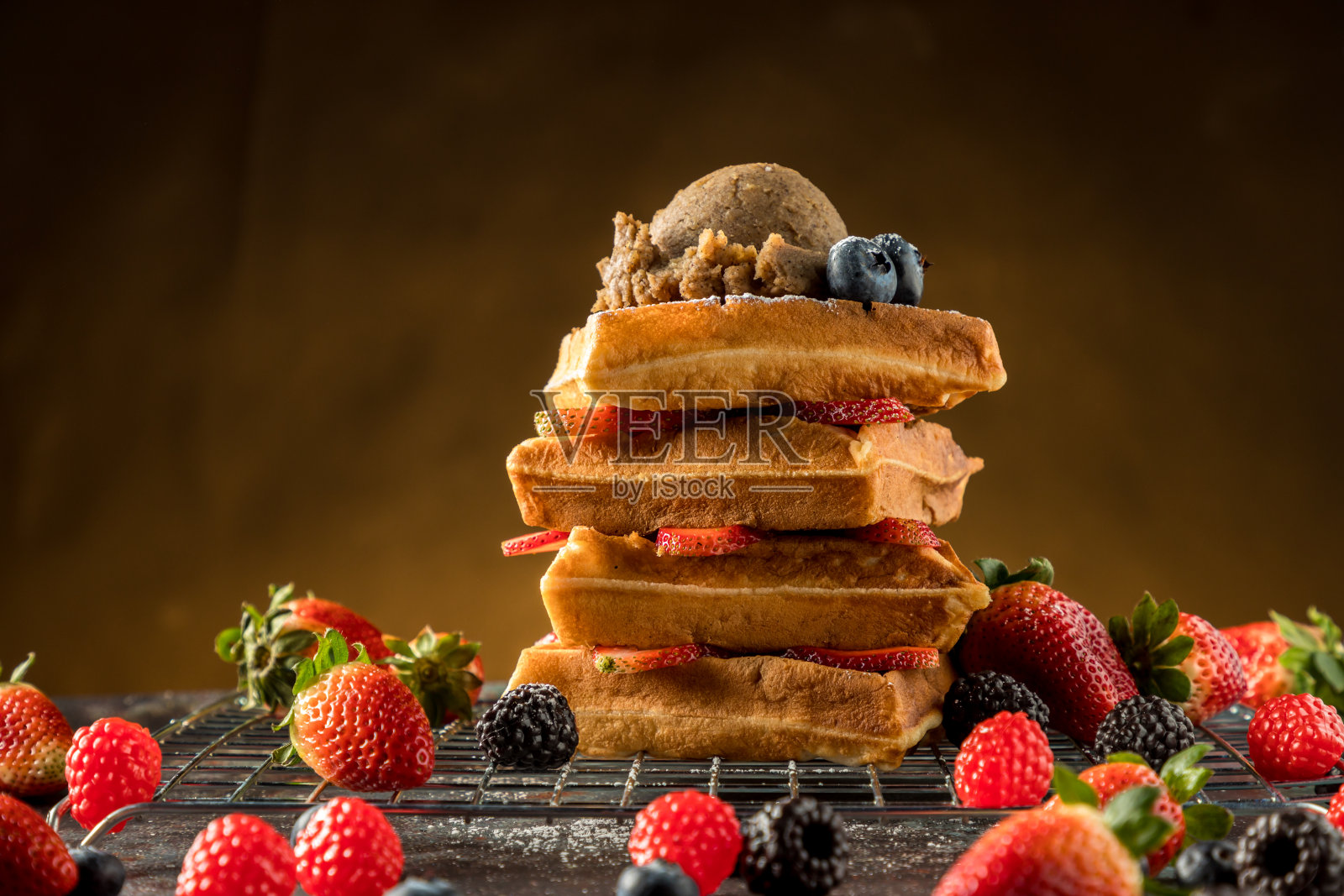 华夫饼配冰淇淋，焦糖酱和新鲜浆果。美味的草莓华夫饼和冰淇淋在咖啡厅。照片摄影图片