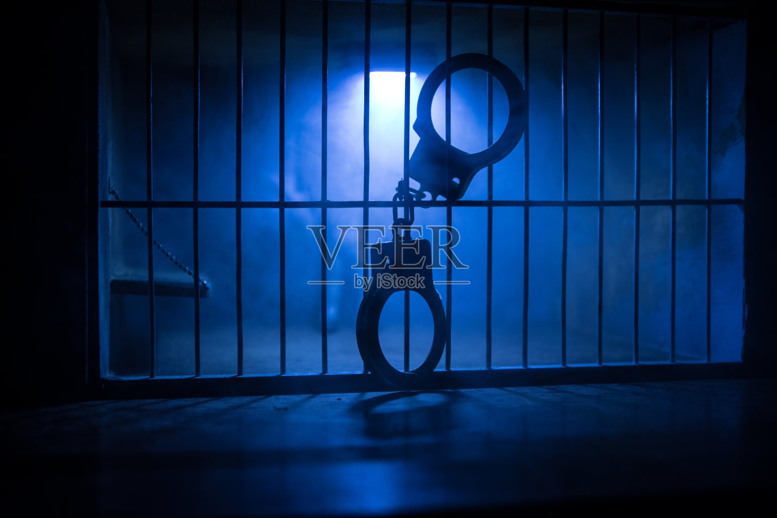 监狱或牢房。男人在监狱里，男人在监狱里。又老又脏的监狱迷你版。黑暗监狱内部创意装修。有选择性的重点照片摄影图片