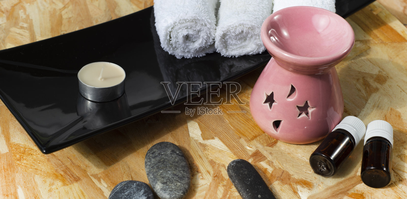 家庭水疗的配件。按摩滚轮。按摩刷。卷毛巾。香薰灯和按摩石。木制背景。为文本复制空间。照片摄影图片