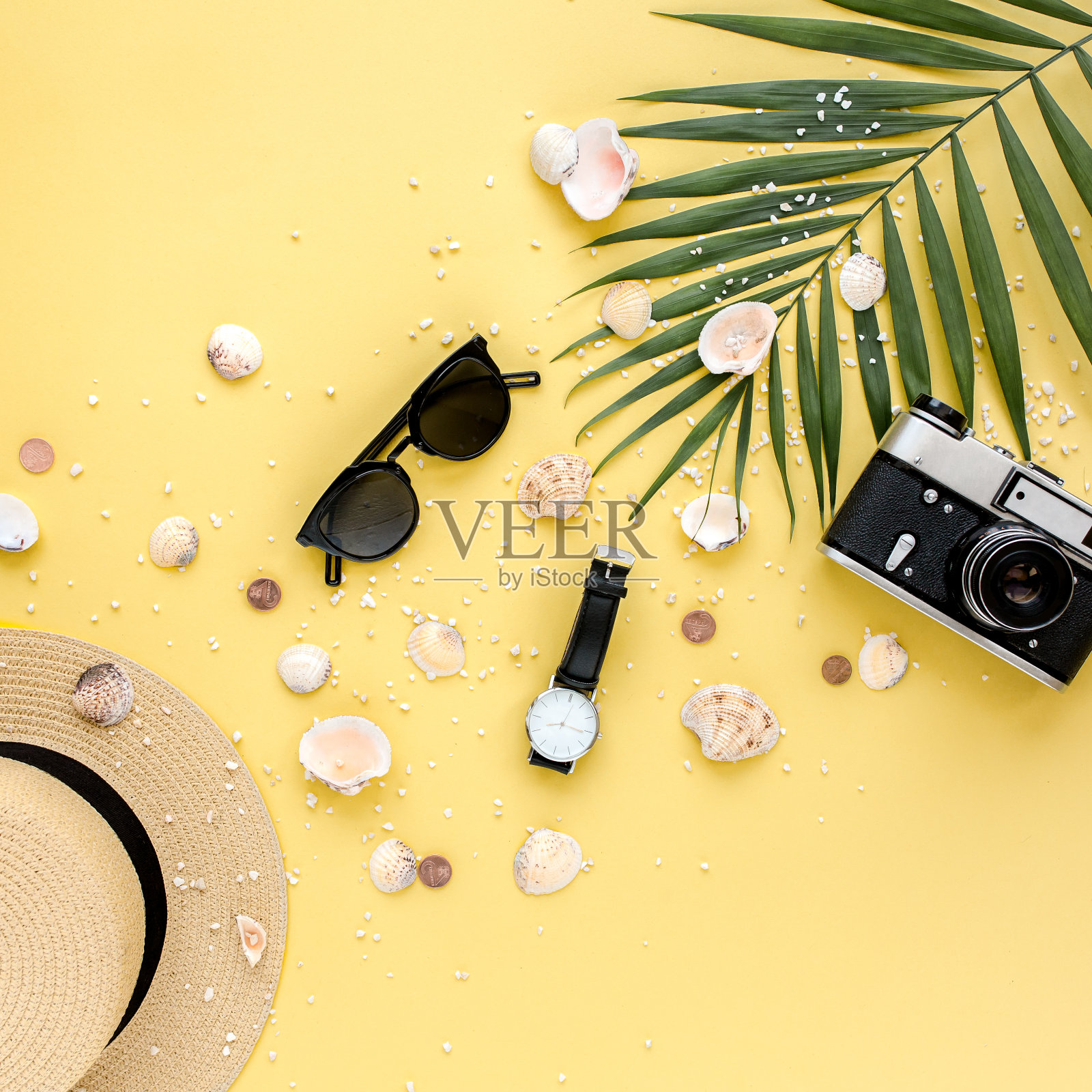 黄色背景的旅行者配件，棕榈叶，相机和太阳镜。平躺，俯视图。夏天的背景照片摄影图片