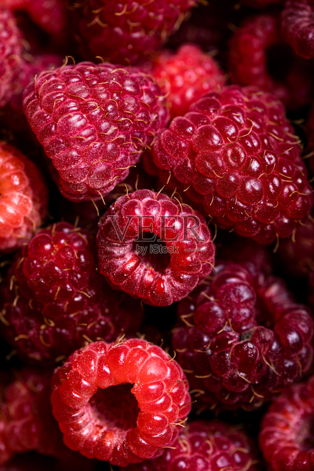 新鲜甜美的红覆盆子口感。水果堆背景照片摄影图片