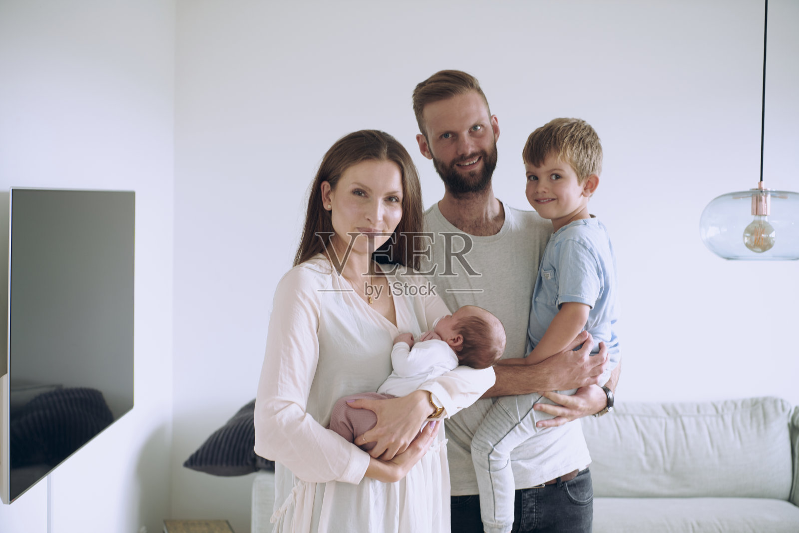 有两个孩子站在客厅的一家人照片摄影图片