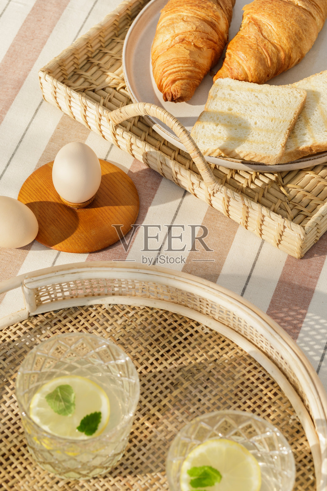 时尚的户外厨房空间组成与木桌，食品，饮料，厨房配件，米色桌布和夏天的树影。乡村的心情。模板。照片摄影图片