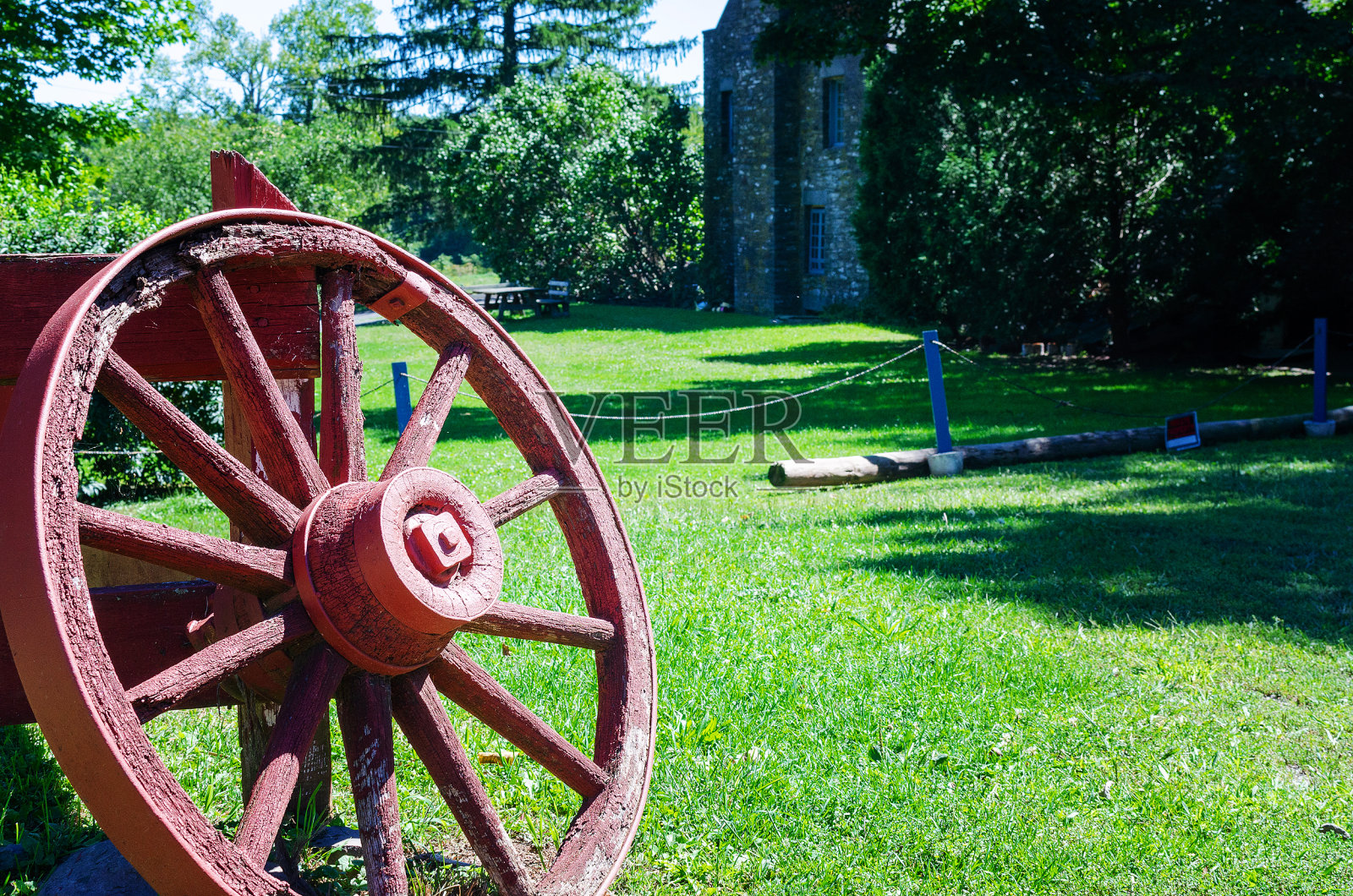 农场里马车帐篷里的旧轮子。背景是旧房子照片摄影图片