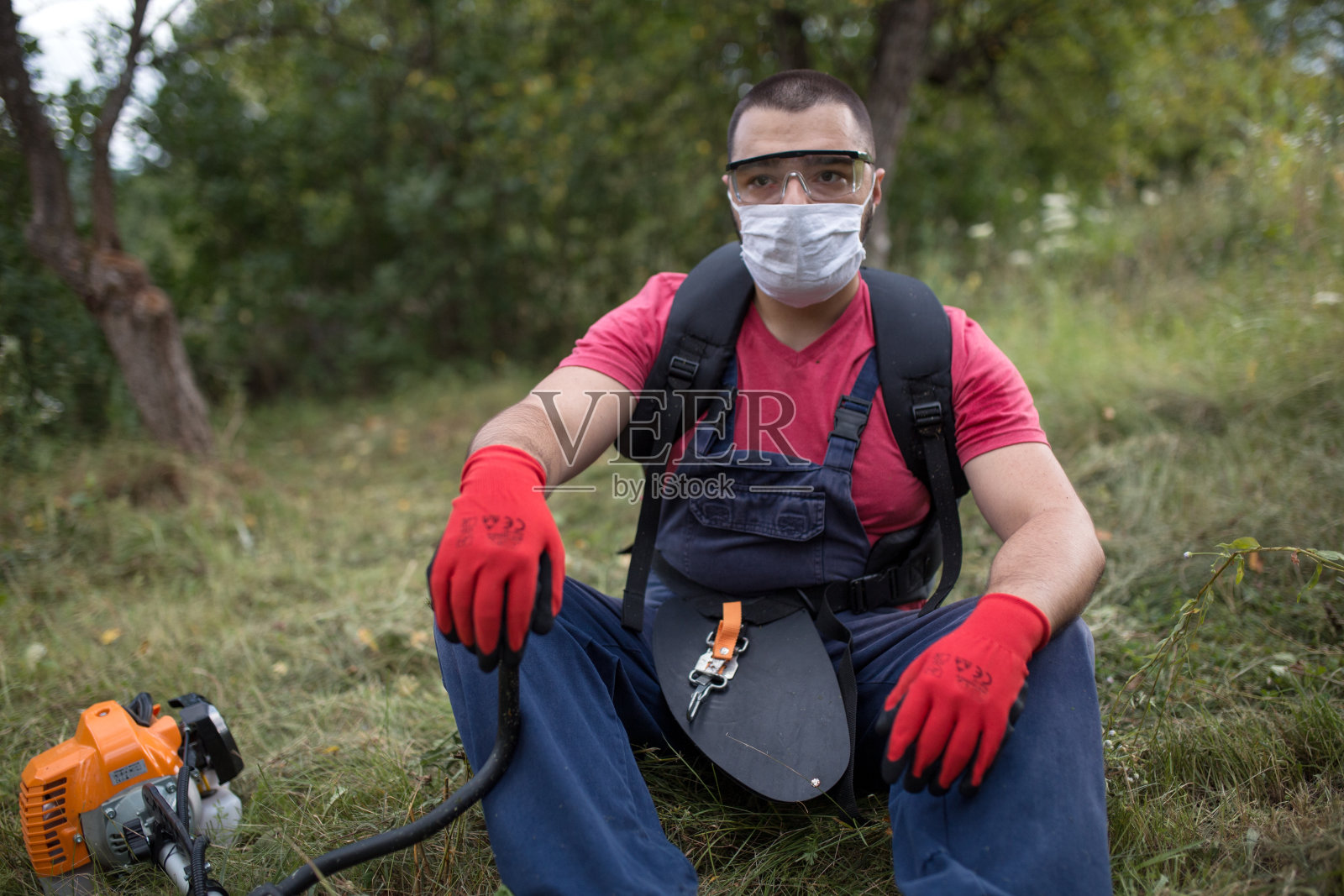 年轻的农民戴着防护口罩在田间劳作照片摄影图片