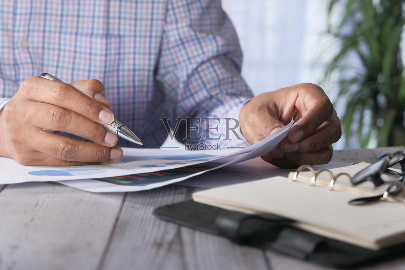 人手用笔在纸上分析条形图照片摄影图片