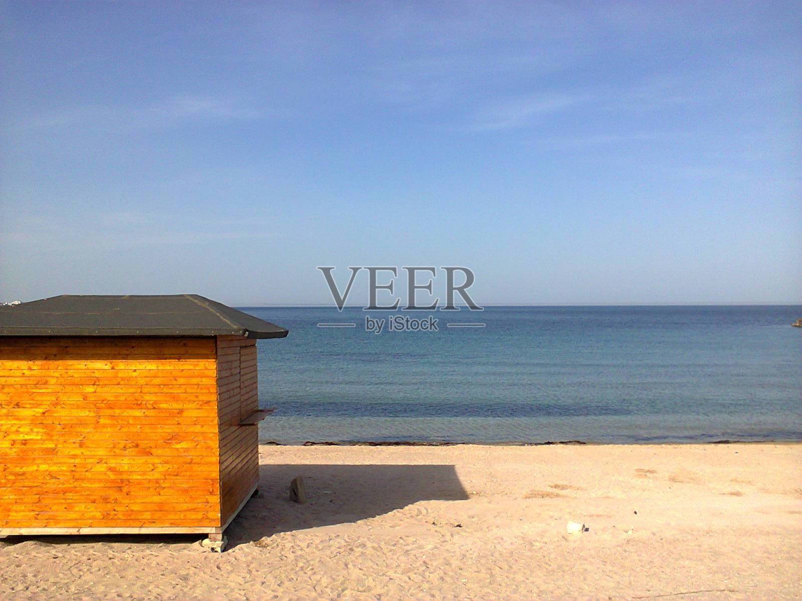 夏天阳光明媚，蓝天透明，翠绿色，小橙海滩小屋照片摄影图片