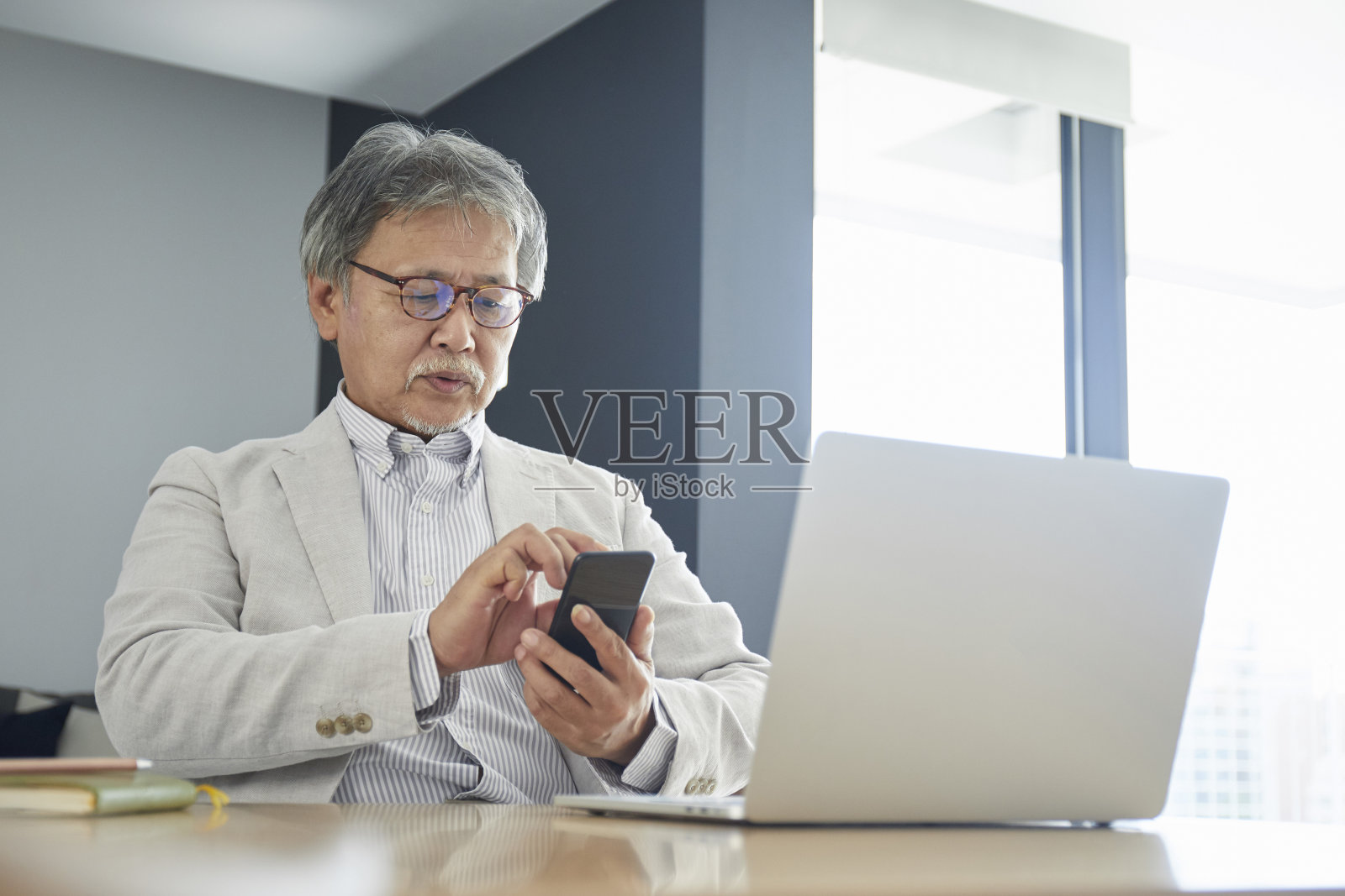 在房间里用智能手机的老人照片摄影图片