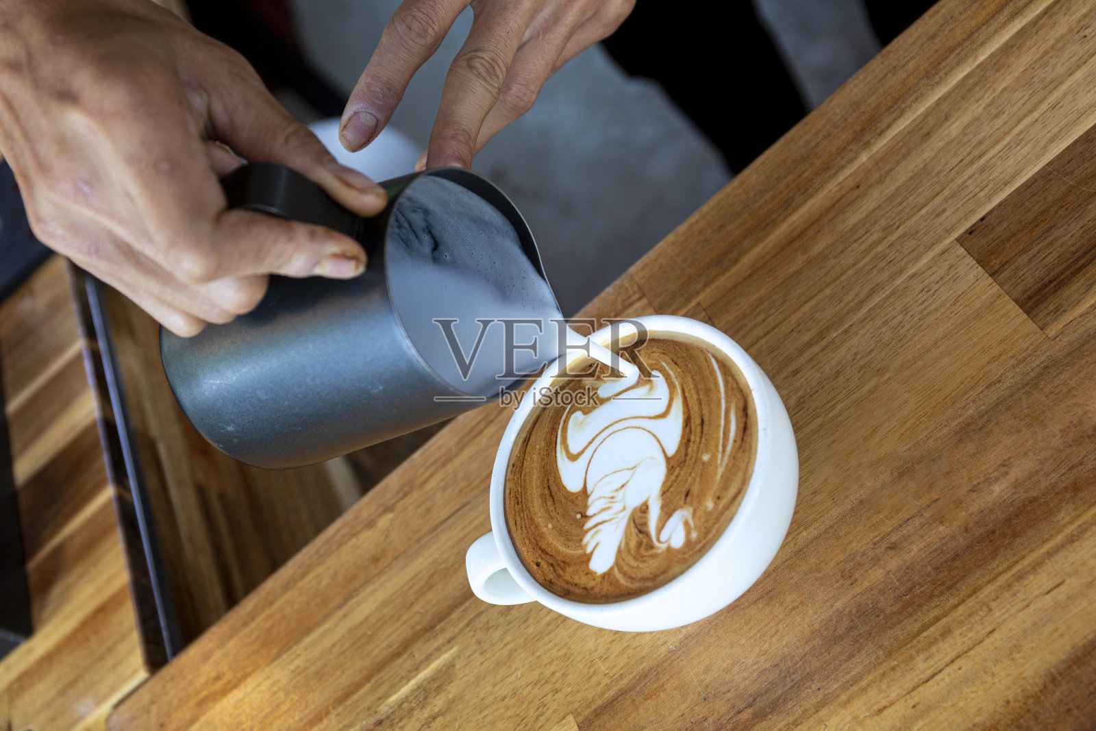 咖啡店木桌上的白杯艺术咖啡。照片摄影图片