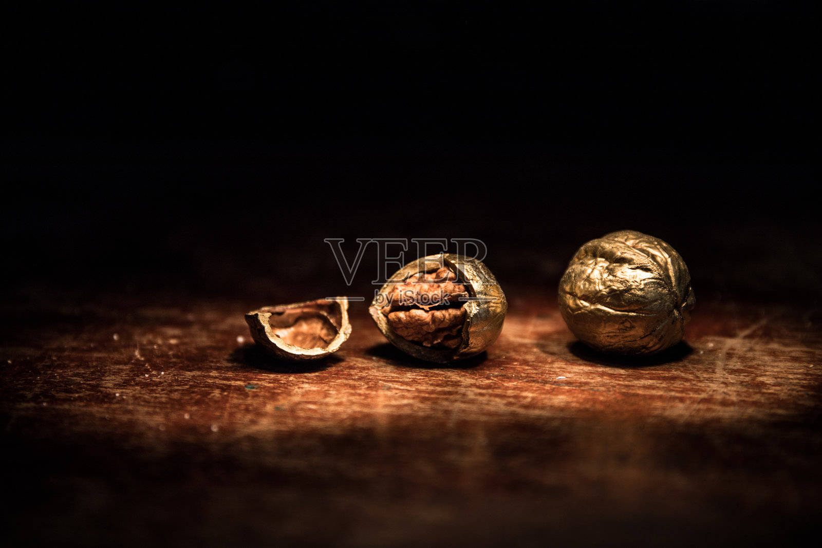 胡桃仁和整个核桃放在质朴的旧木桌上的静物画。创造性的表装饰。照片摄影图片