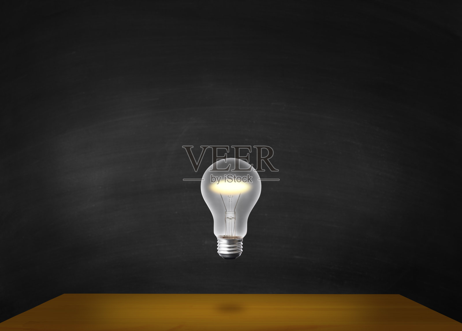 靠在黑板上的木桌上方，灯泡在半空中闪闪发光。照片摄影图片