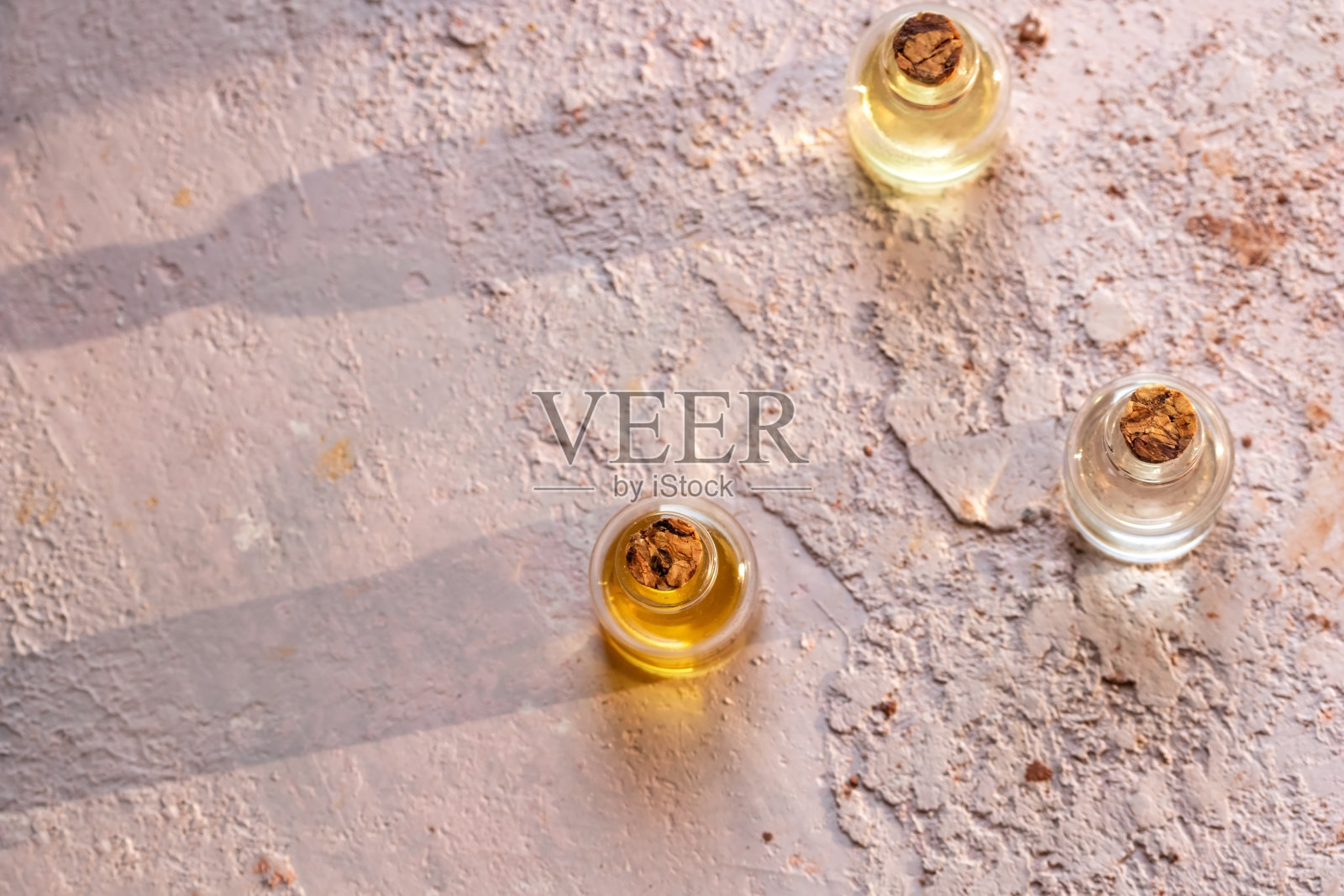 空的粉色背景上的精油瓶照片摄影图片