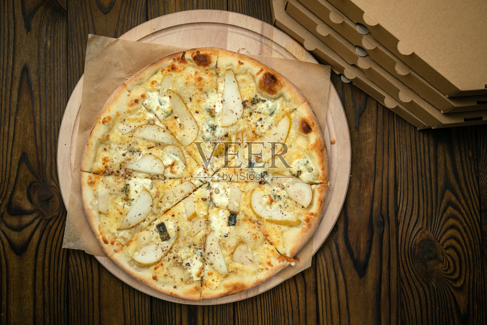 披萨放在棕色的木桌上。照片摄影图片