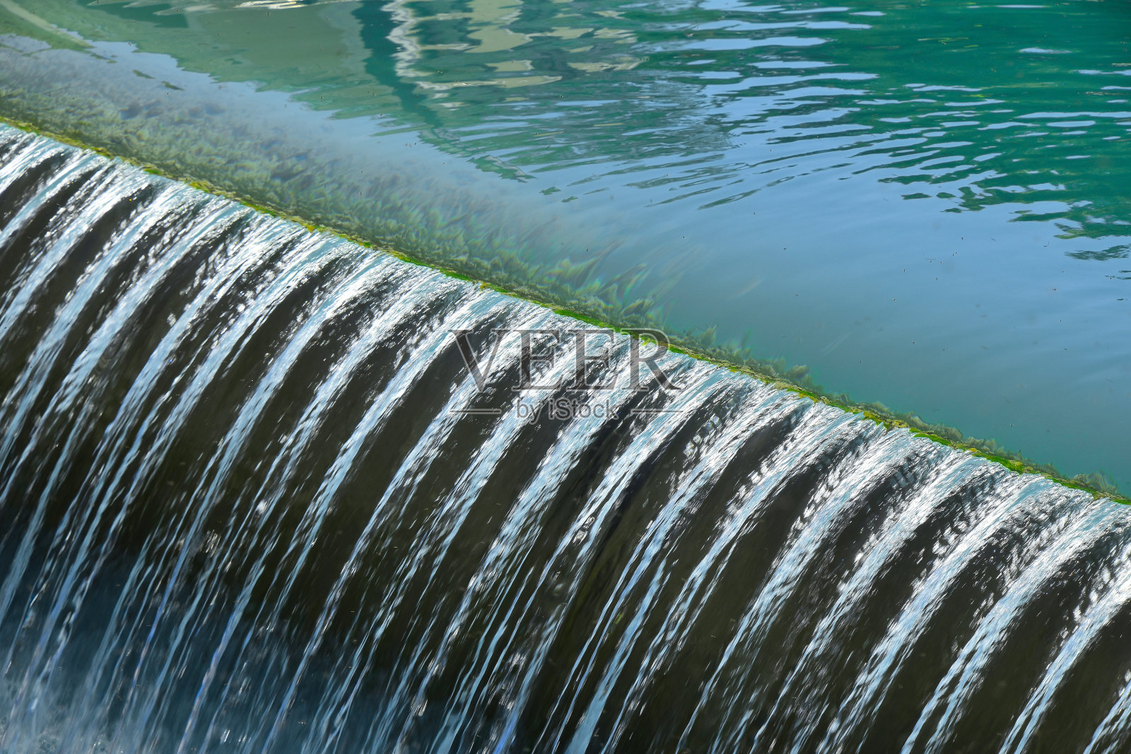 碧蓝的河水从裂缝中泡沫飞溅而下照片摄影图片