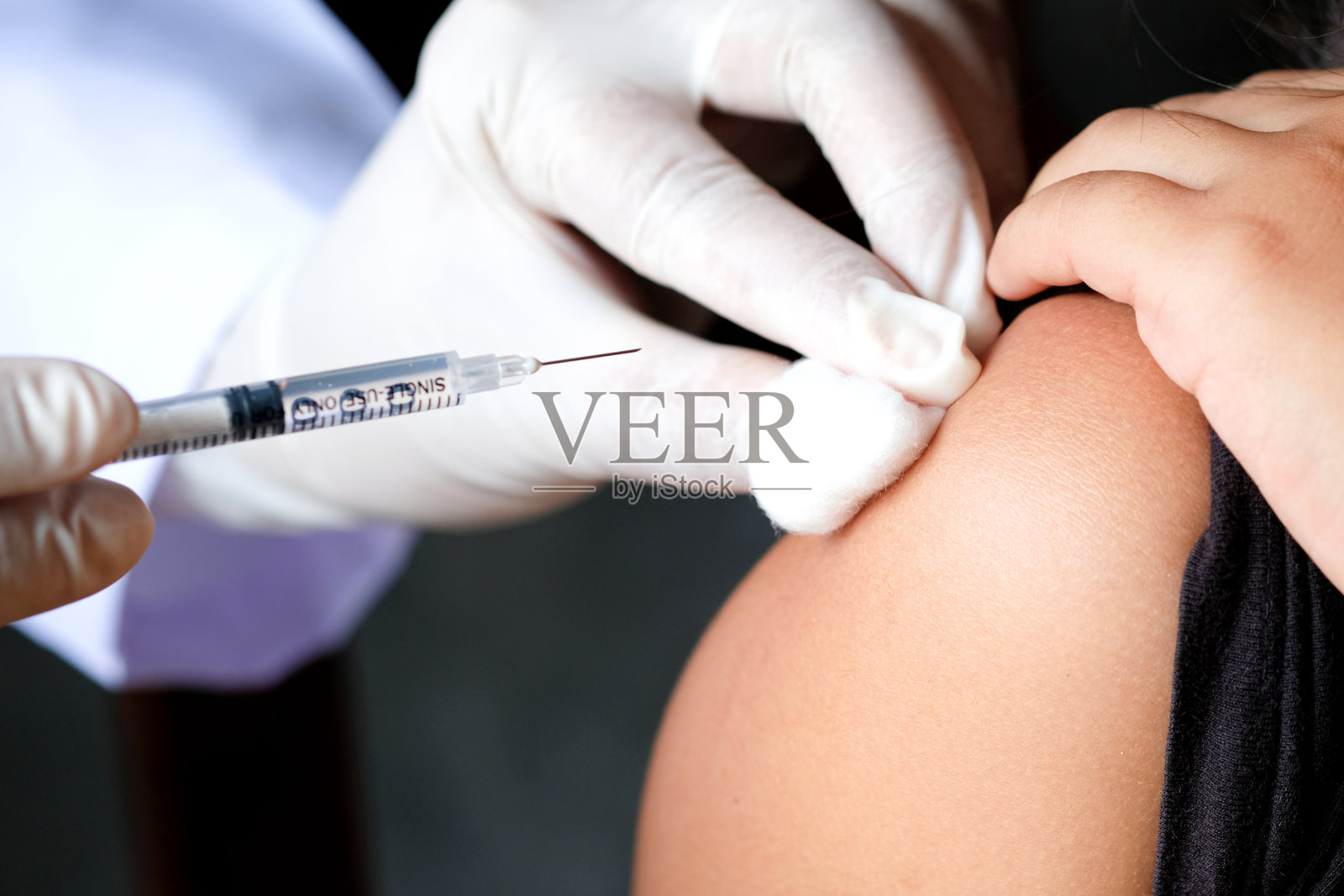 在医院里，医生手里拿着一个注射器和一个蓝色的疫苗瓶。健康和医学概念。照片摄影图片