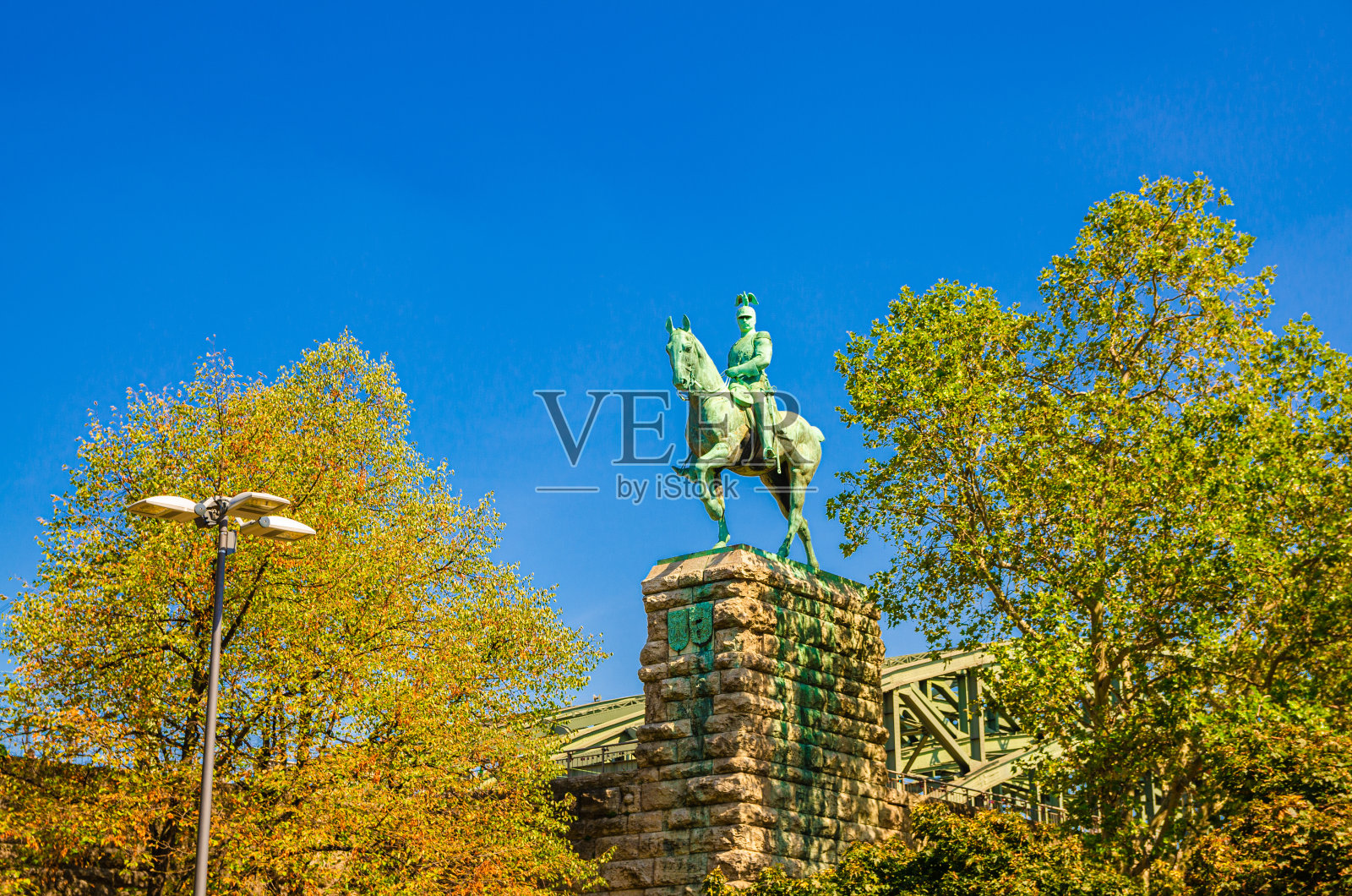 德国，北莱茵-威斯特伐利亚，科隆历史中心霍亨索伦桥附近的石基上的德皇威廉二世骑马雕像，晴朗的天空背景，阳光明媚的一天照片摄影图片