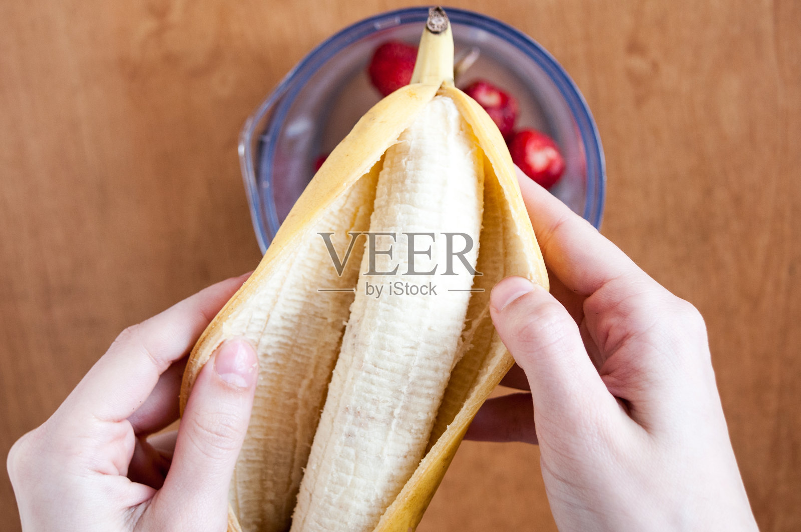 用手在搅拌机上剥香蕉，俯视图照片摄影图片