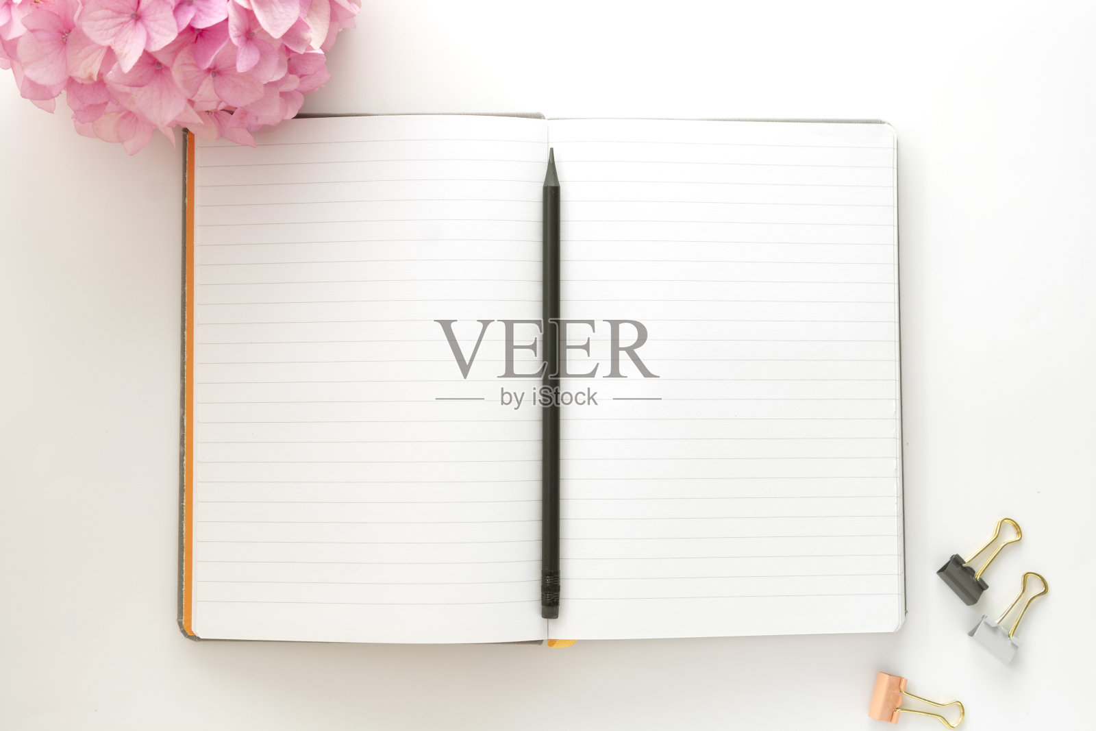 桌面打开笔记本与铅笔和粉红色绣球花。副本的空间。照片摄影图片