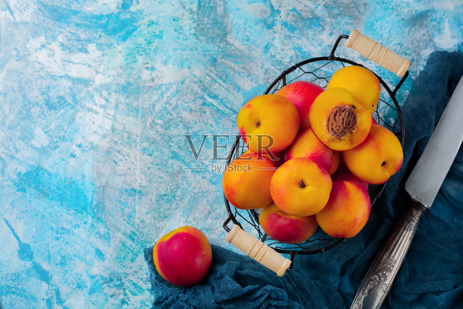 新鲜多汁的水果油桃在金属网格上的蓝色混凝土背景。有选择性的重点。前视图。乡村风格。照片摄影图片