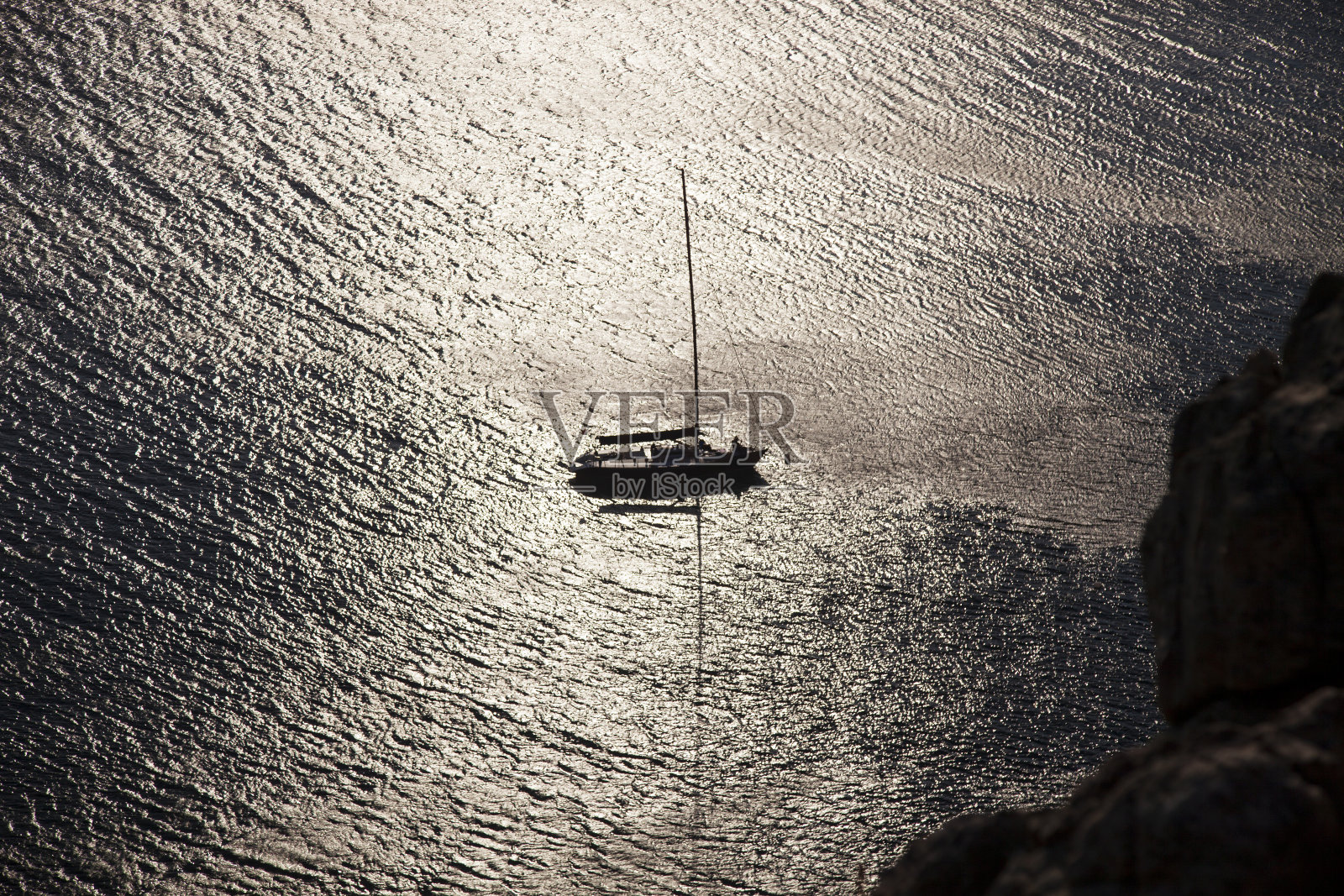 波光粼粼的海面上帆船的剪影照片摄影图片