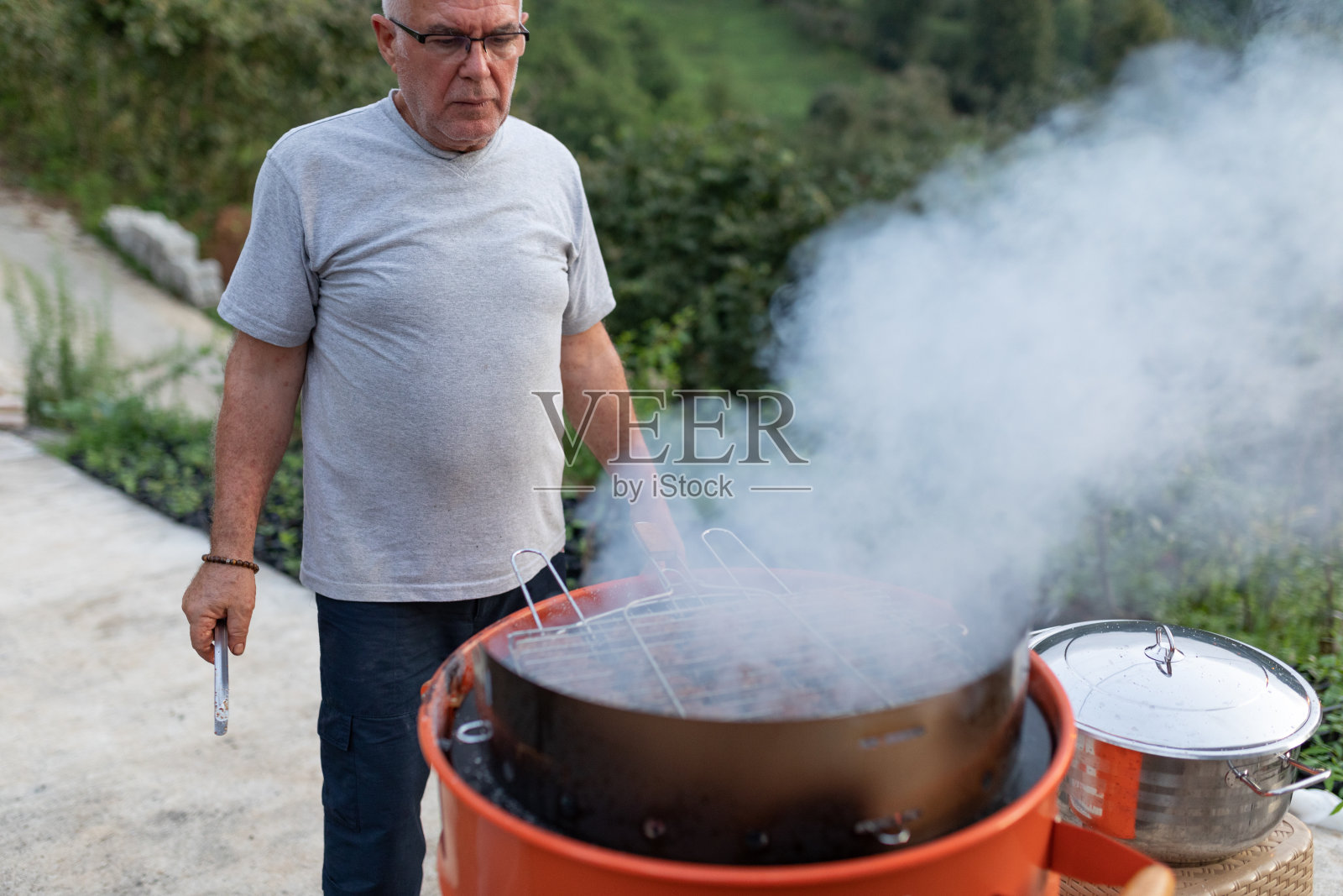 在烧烤架上烤肉的男人照片摄影图片