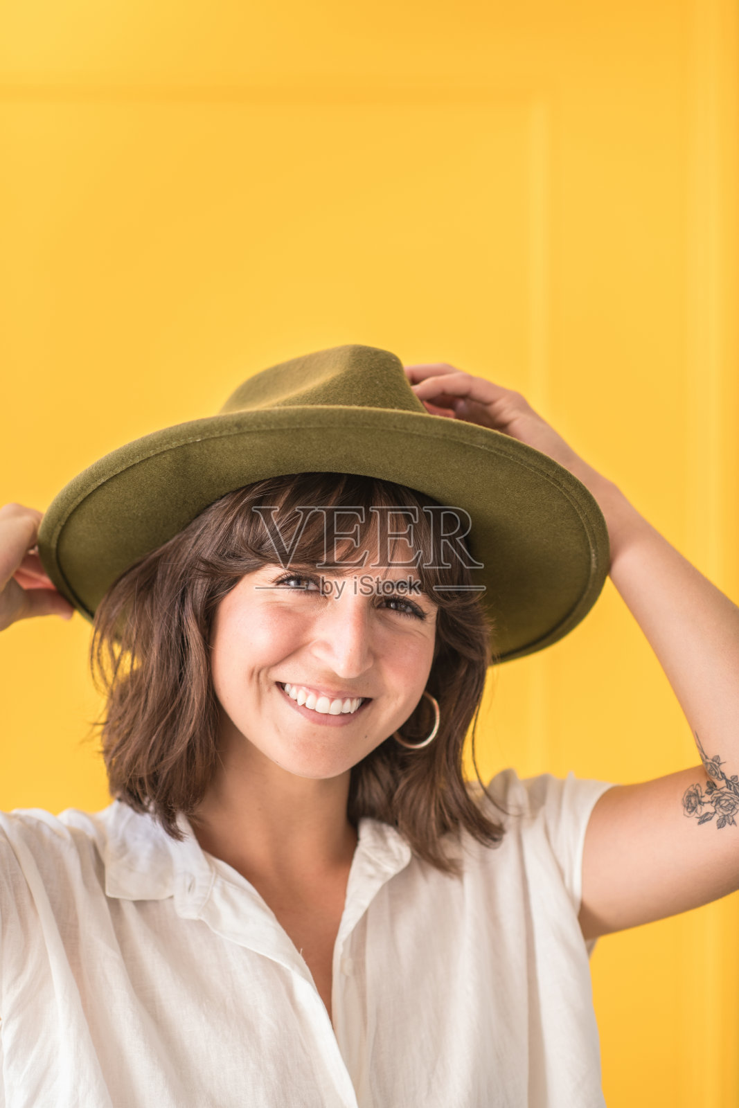 戴着帽子的年轻女子在黄门前微笑照片摄影图片