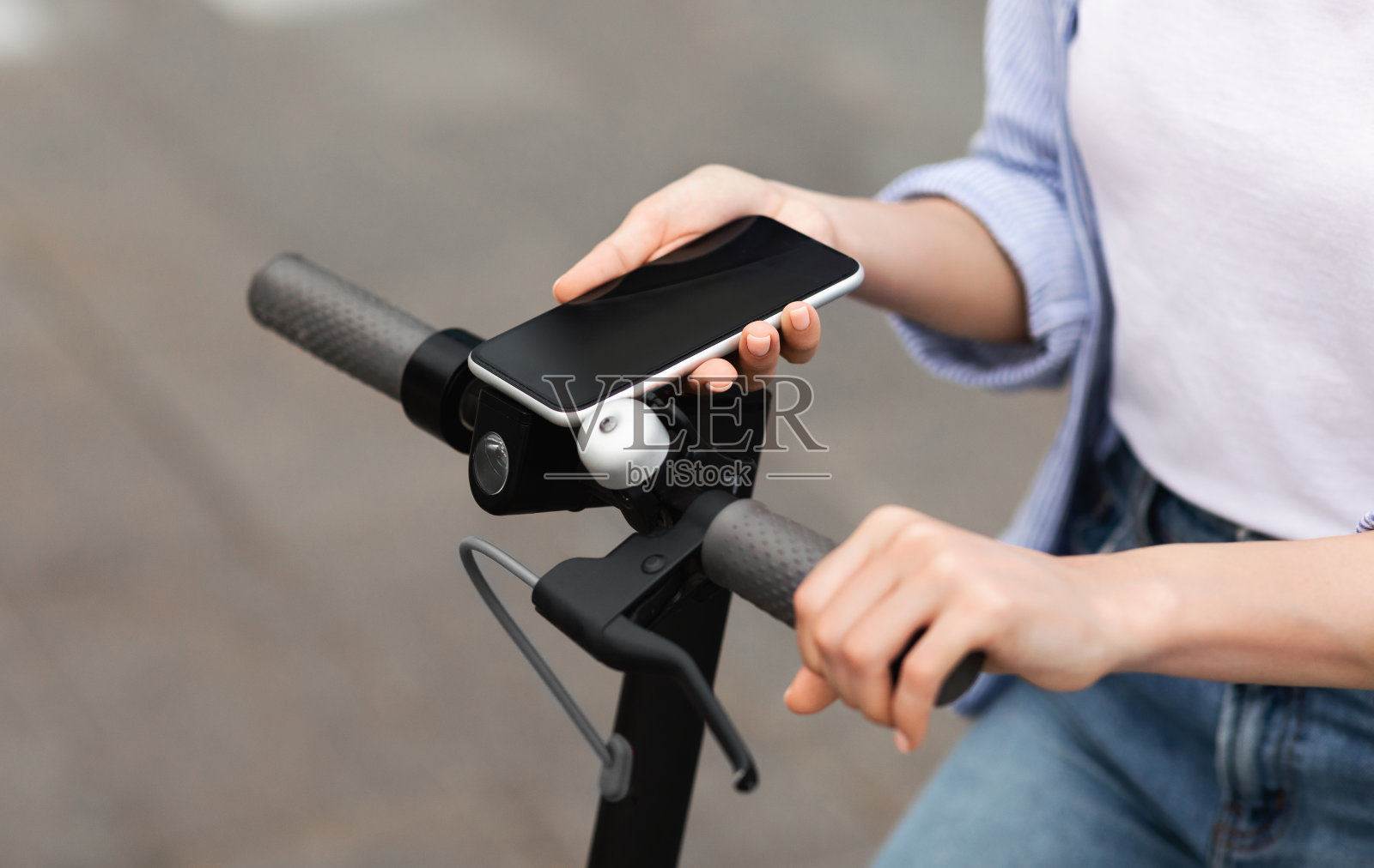 女孩骑电动滑板车，用手机照片摄影图片