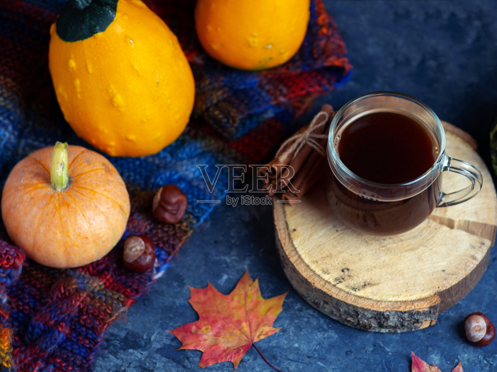 一杯热腾腾的咖啡，枫叶的红叶，南瓜和一条温暖的针织围巾构成了秋天的季节照片摄影图片