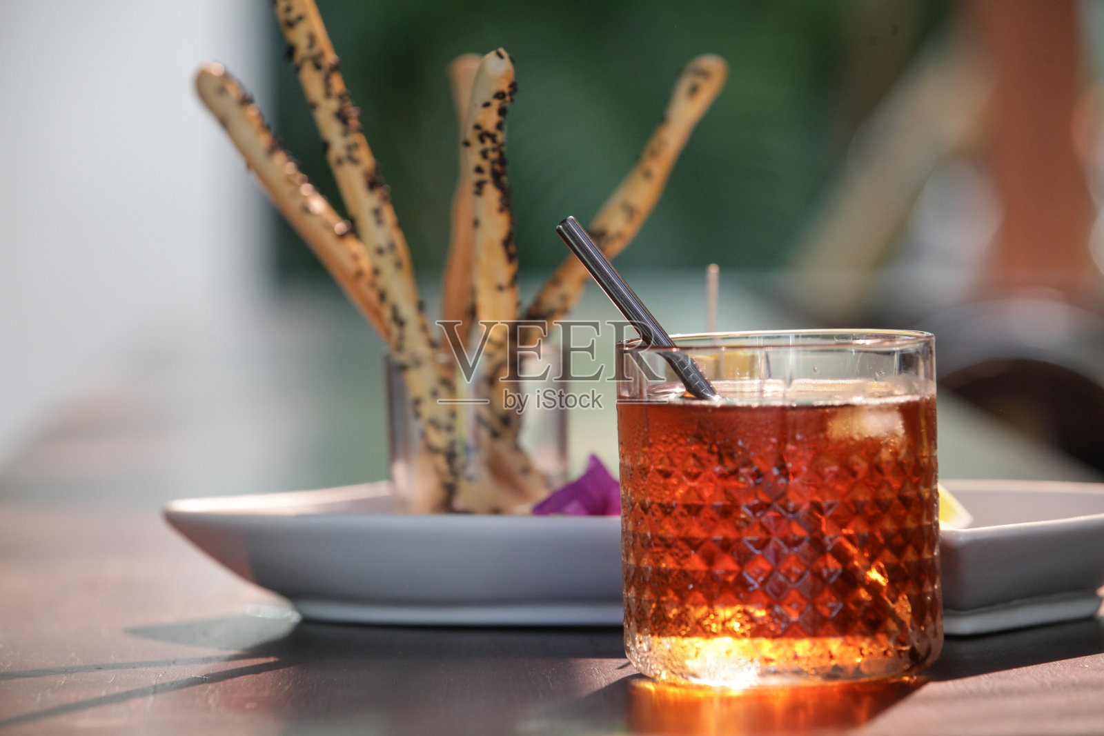 咸棍和冰茶被端上了餐厅的桌子。照片摄影图片