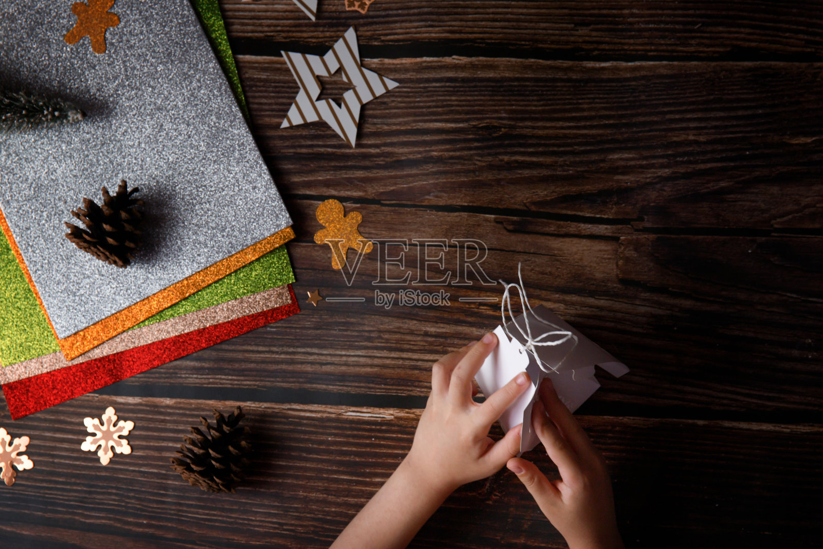 孩子们在木制背景上玩圣诞工艺品。桌上放着节日物品。照片摄影图片