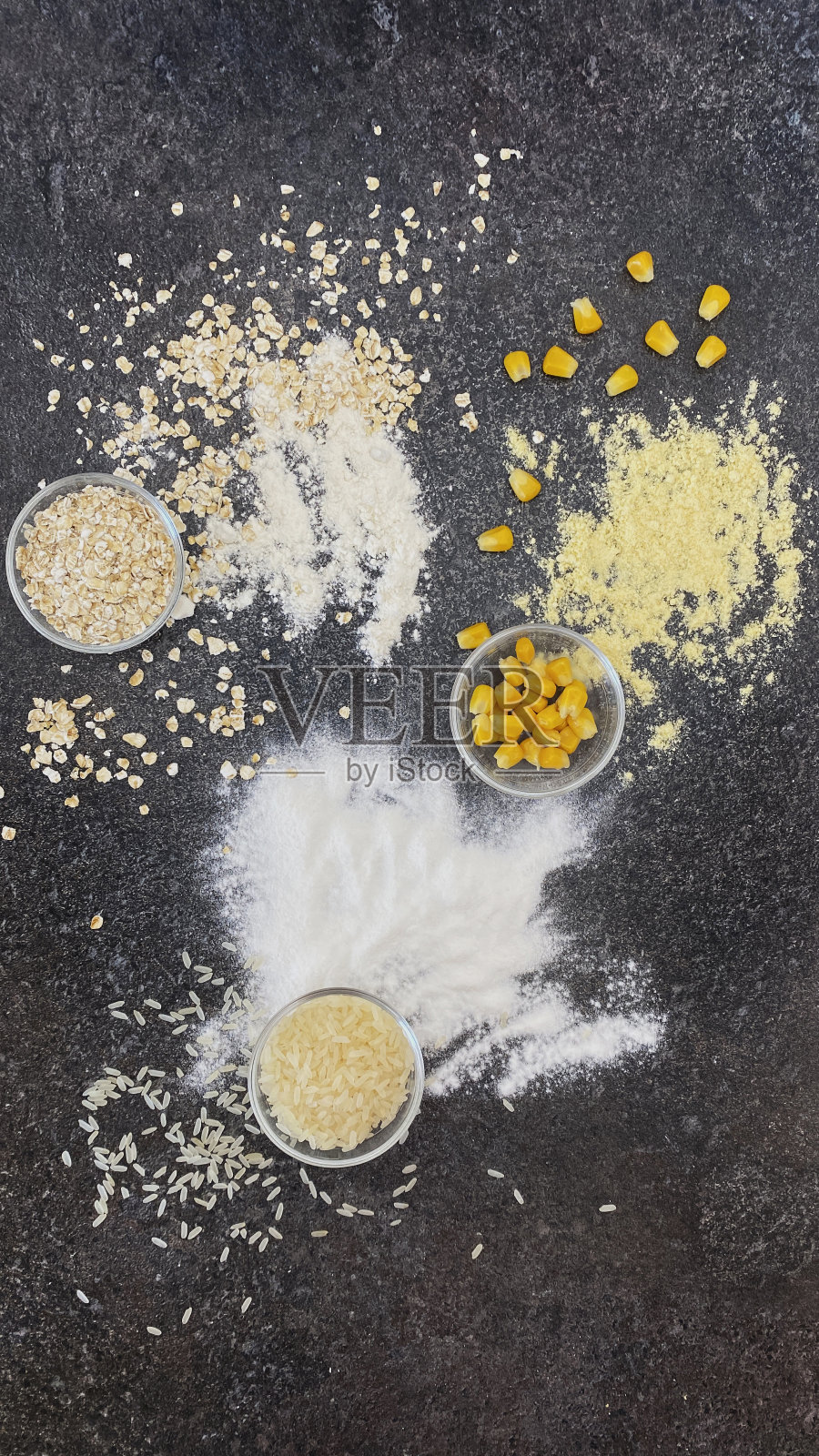 黑色纹理背景上的燕麦、玉米粉和玉米片、米粉和大米照片摄影图片