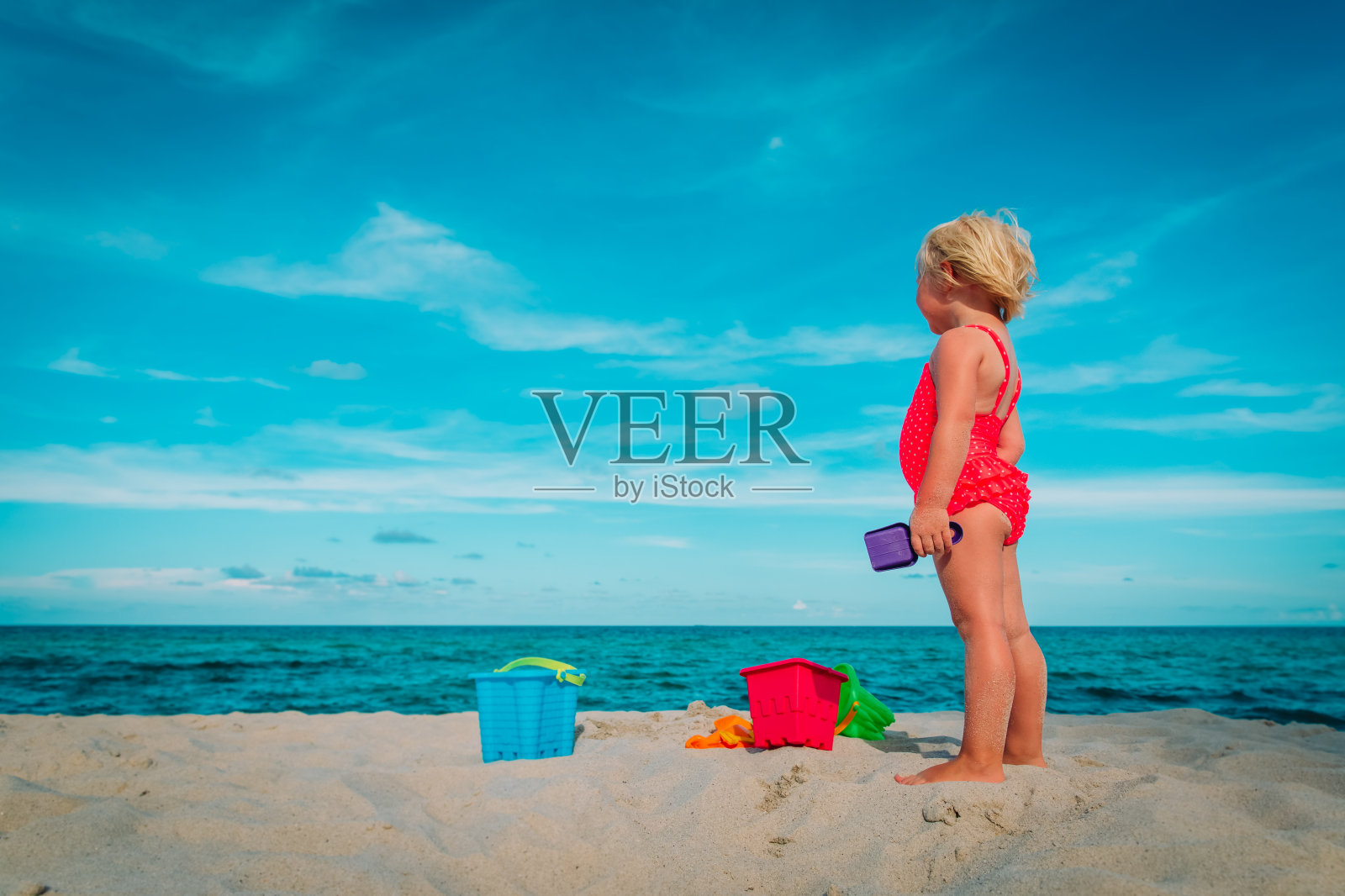 小女孩在沙滩上玩沙子和玩具照片摄影图片