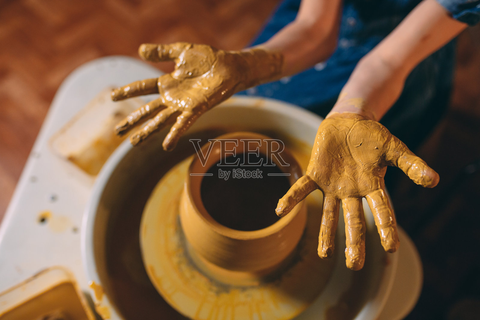 陶器作坊。一个小女孩用粘土做了一个花瓶。粘土建模照片摄影图片