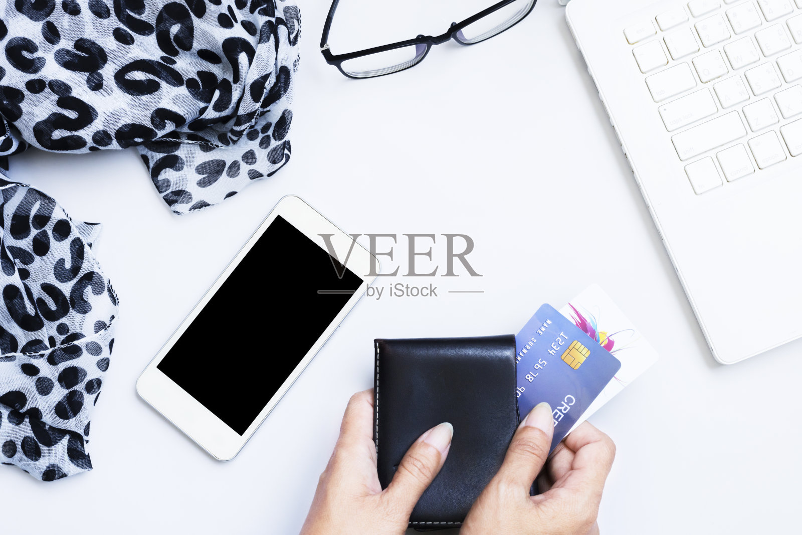 手持黑色钱包和信用卡，黑屏智能手机平躺俯视图照片摄影图片