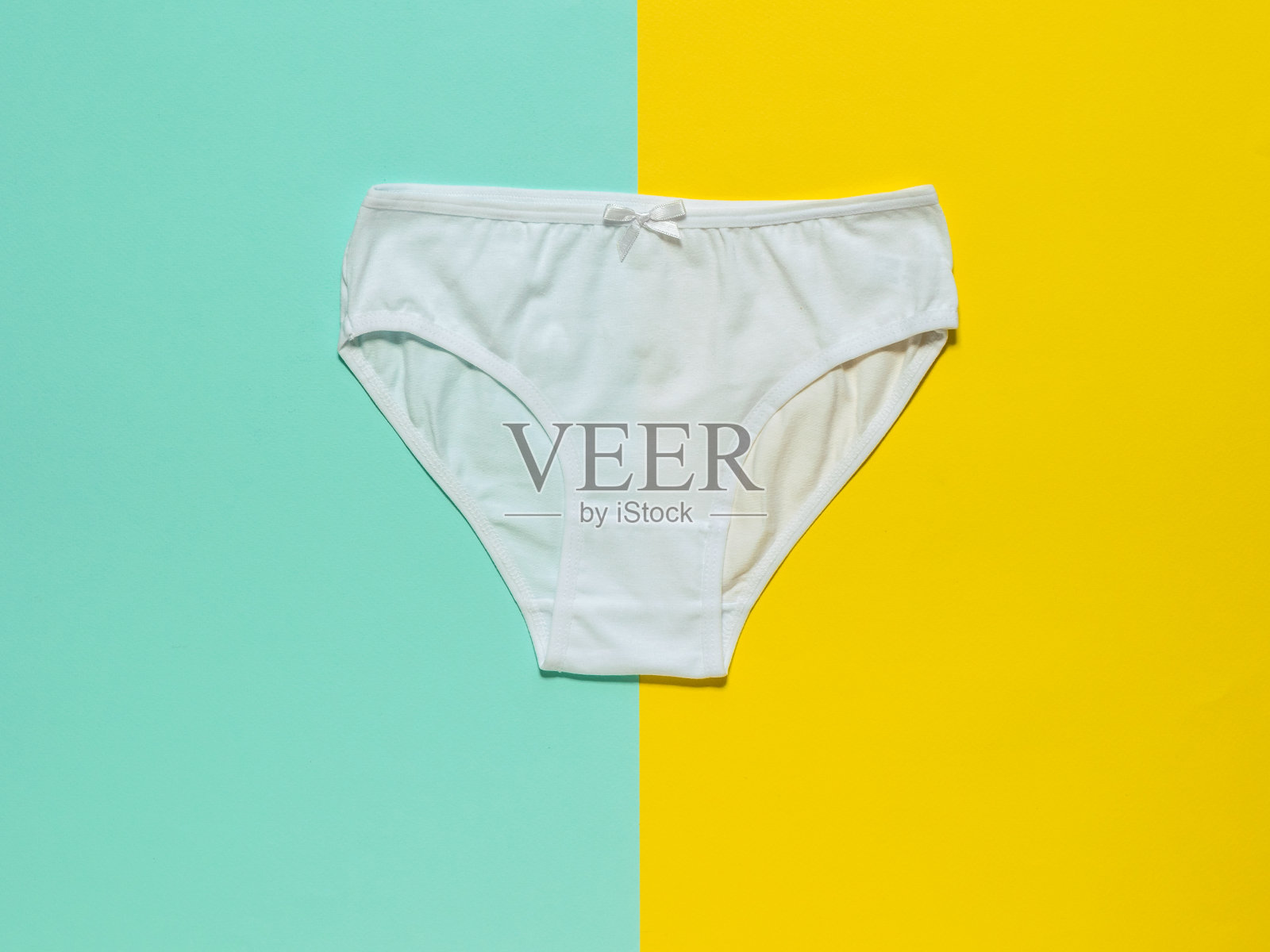 时尚的白色女性内裤上的黄色和绿松石背景。平的。照片摄影图片