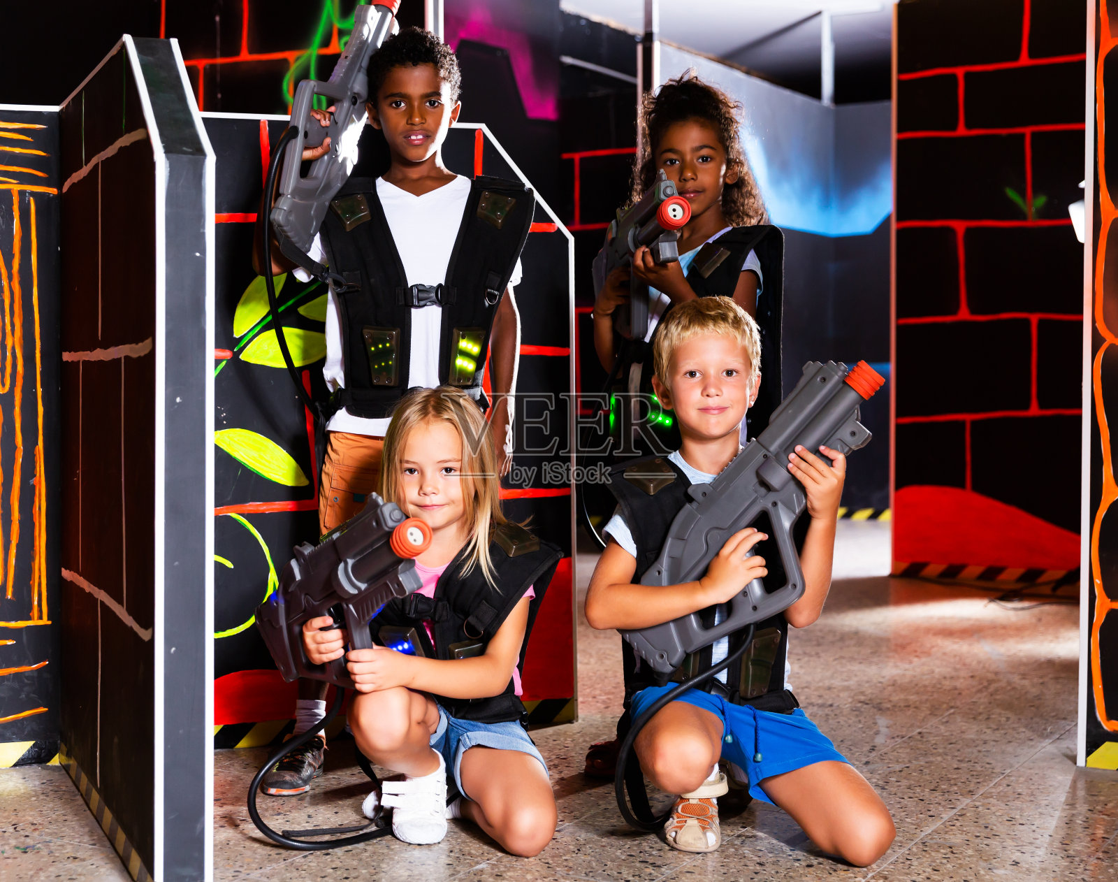 在黑暗的房间里玩激光枪战游戏，快乐的青少年用激光枪瞄准其他玩家照片摄影图片