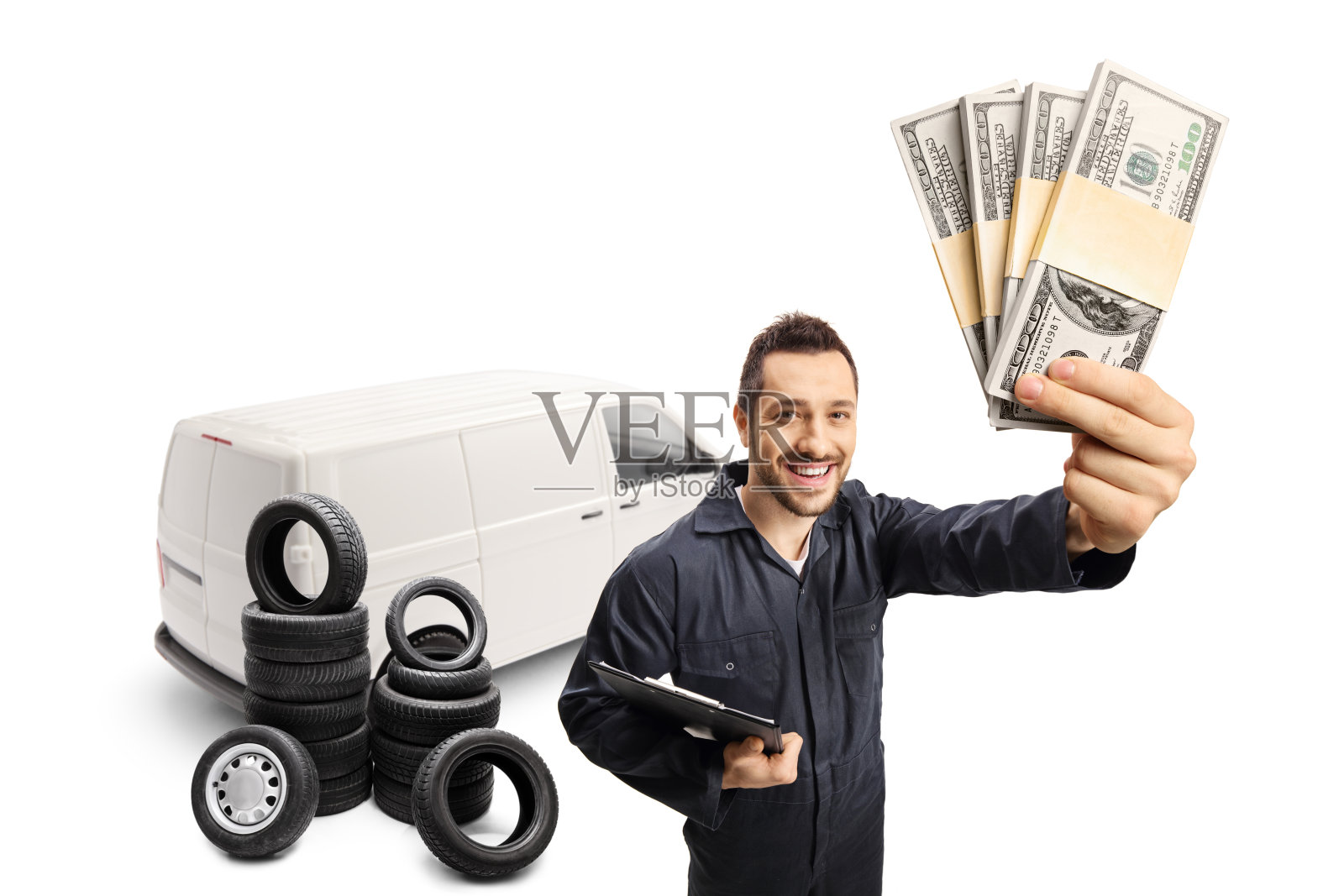 汽车修理工拿着钱站在一辆货车和一堆轮胎前照片摄影图片