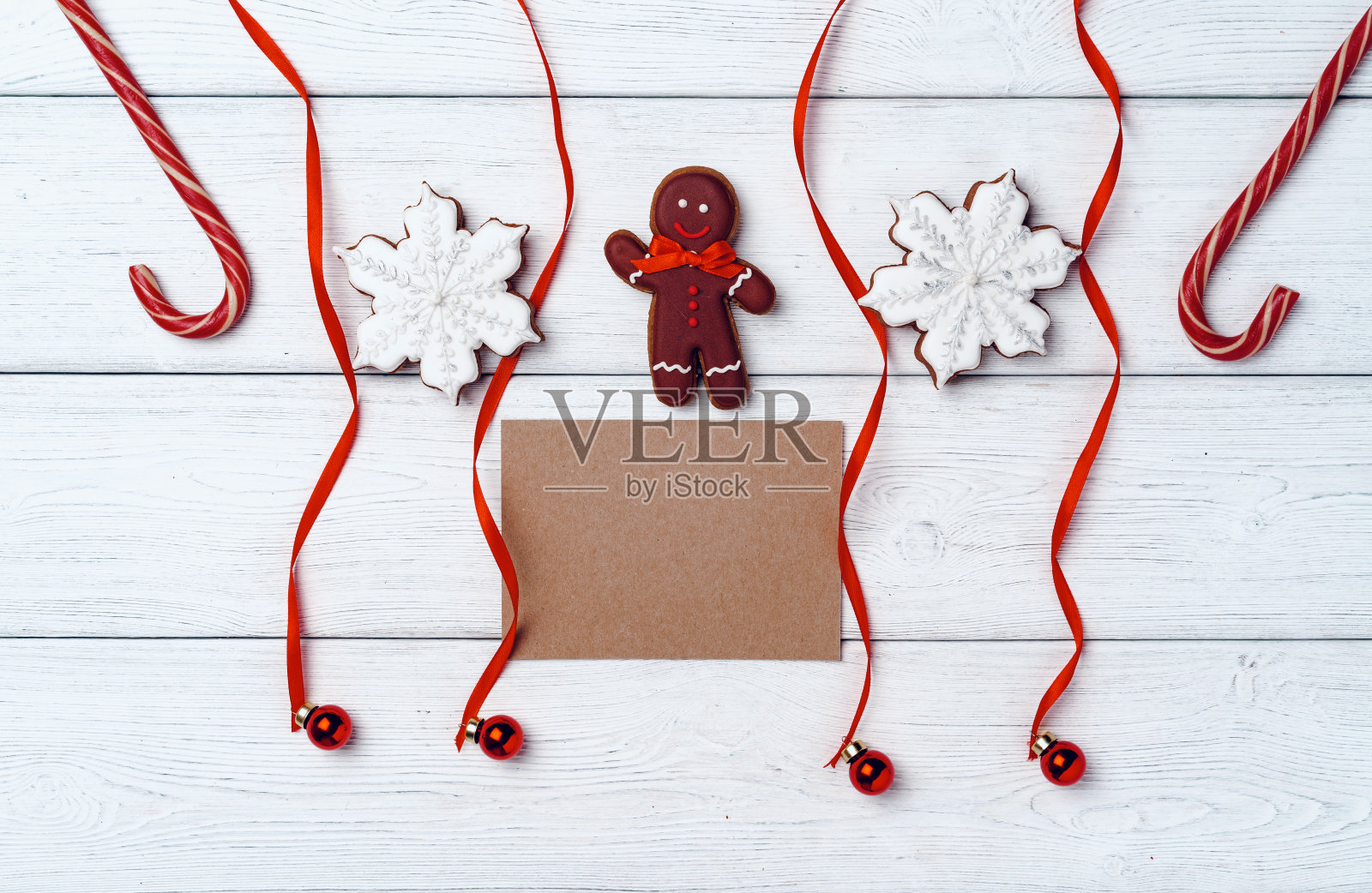 冬天的节日背景与姜饼人和糖果拐杖在白色的木板照片摄影图片