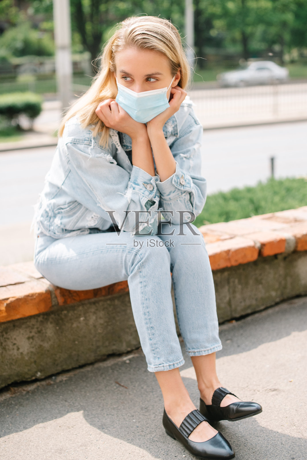 一名年轻女子在城市中戴着抗菌口罩的肖像。照片摄影图片