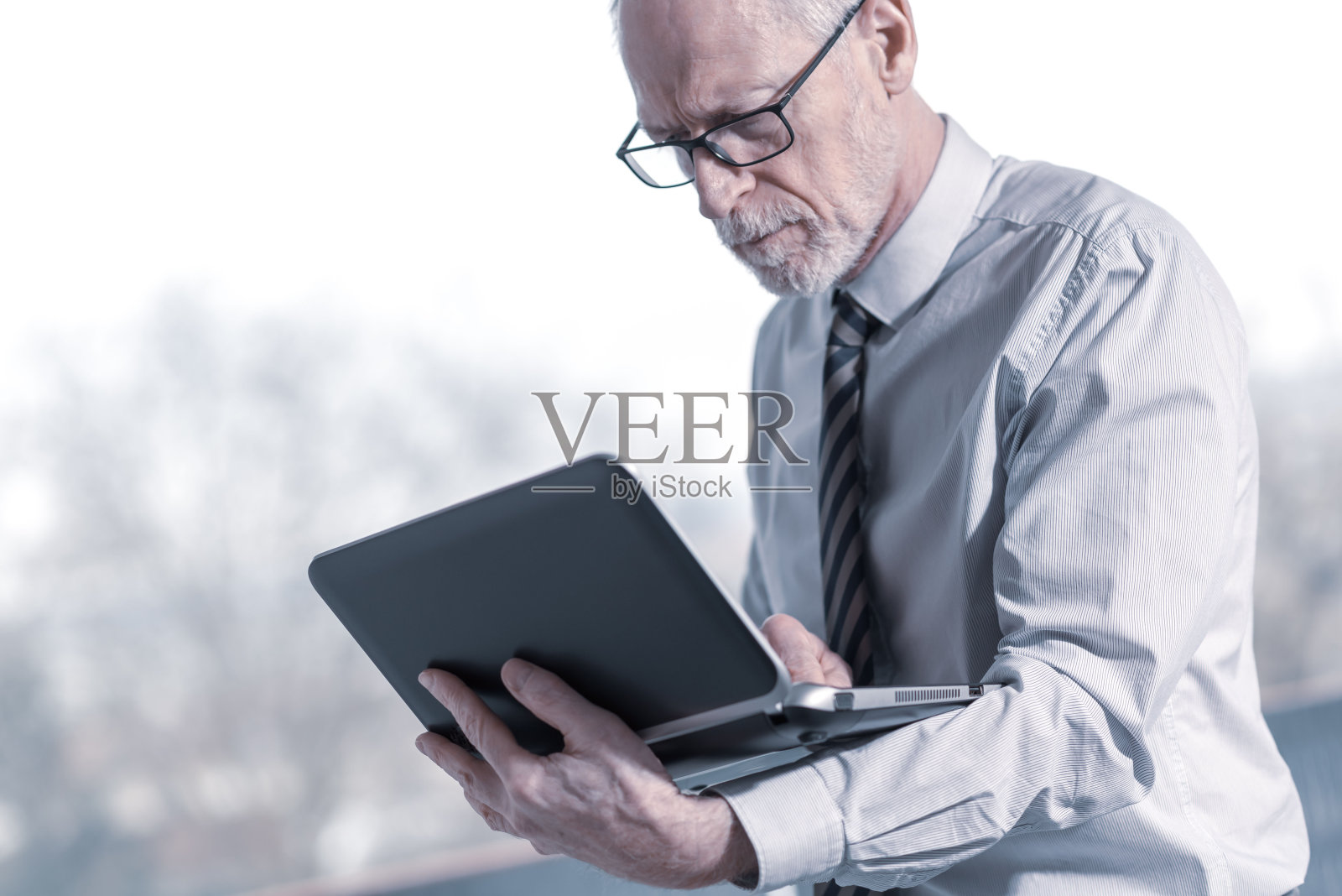 资深商人站在电脑前工作照片摄影图片