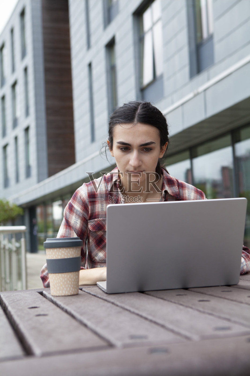 在校园里使用笔记本电脑的女大学生照片摄影图片