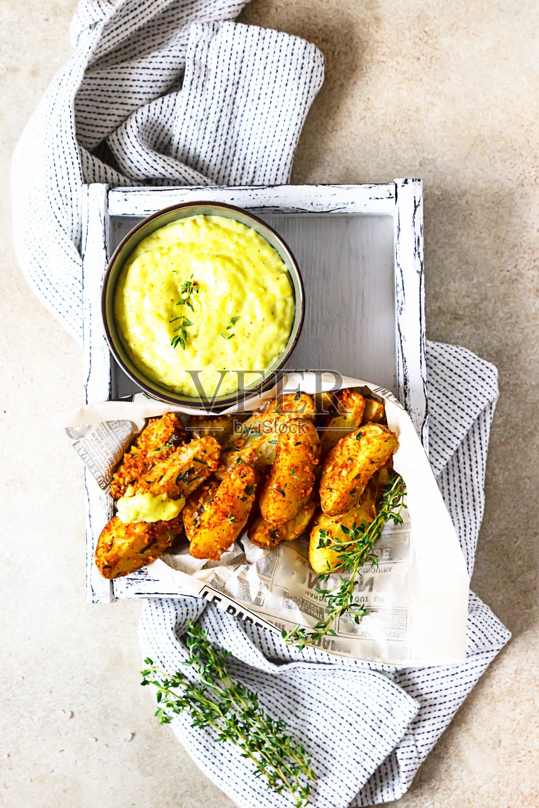 烤制的香脆土豆配百里香芝士酱在陶瓷碗中，浅石背景。前视图。照片摄影图片